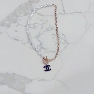 Authentic Chanel charm on pearl and gold tone necklace